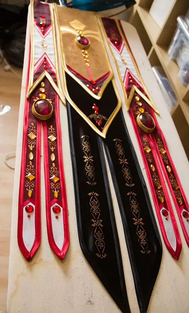 Embroidered Ceremonial Regalia Collars | ZESTLET Red, black and gold decorative ceremonial collars with embroidered motifs and hanging ornaments.
