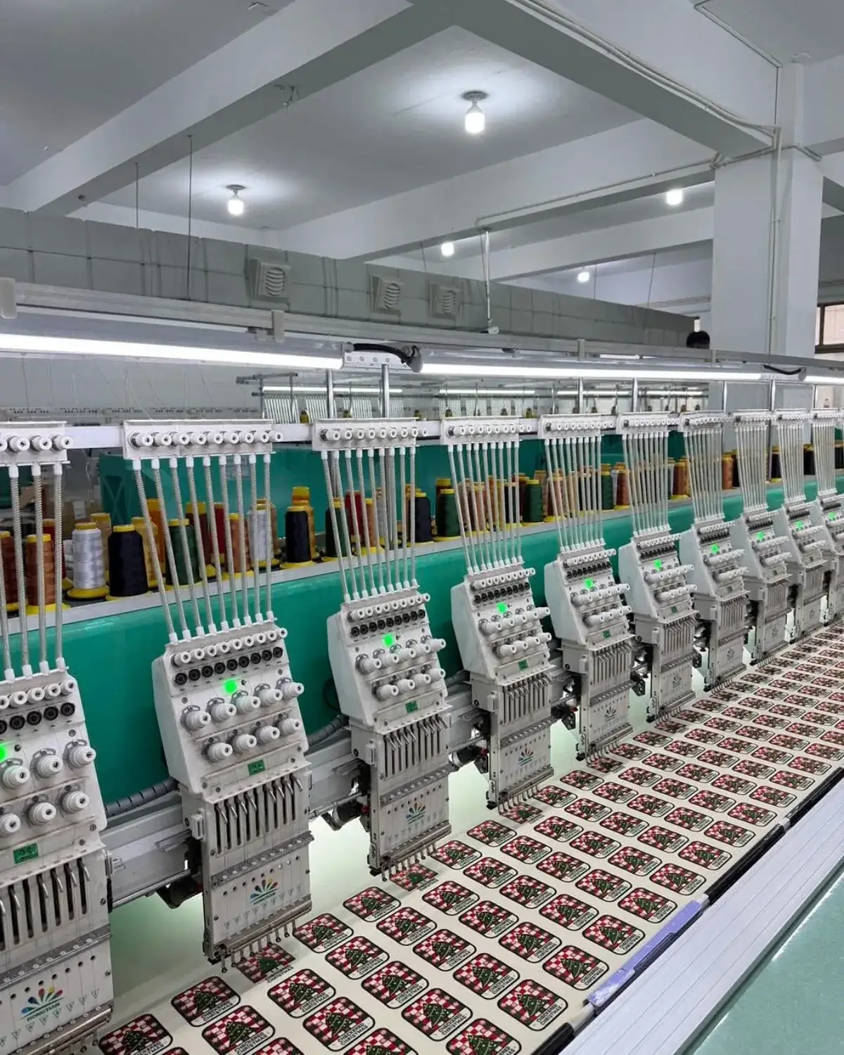 Multi-Head Embroidery Patch Production A multi-head embroidery machine stitching repeated patches on fabric.
