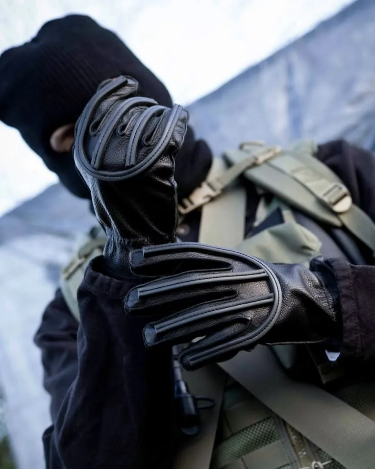 Black Tactical Gloves | ZESTLET Custom Manufacturing Close-up of black tactical gloves with raised knuckle panels and adjustable wrist straps.