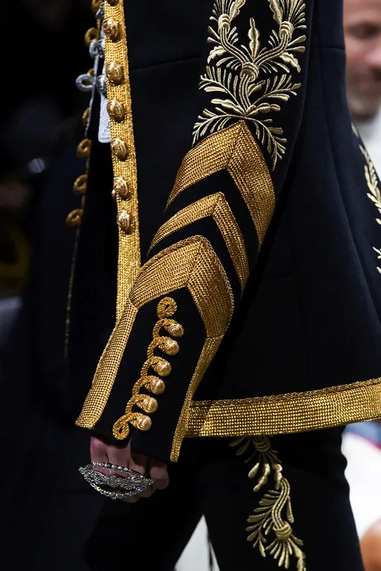 Gold Ceremonial Uniform Embroidery Detail | ZESTLET Close-up of gold braid, buttons and leaf-pattern embroidery on a black ceremonial uniform sleeve.