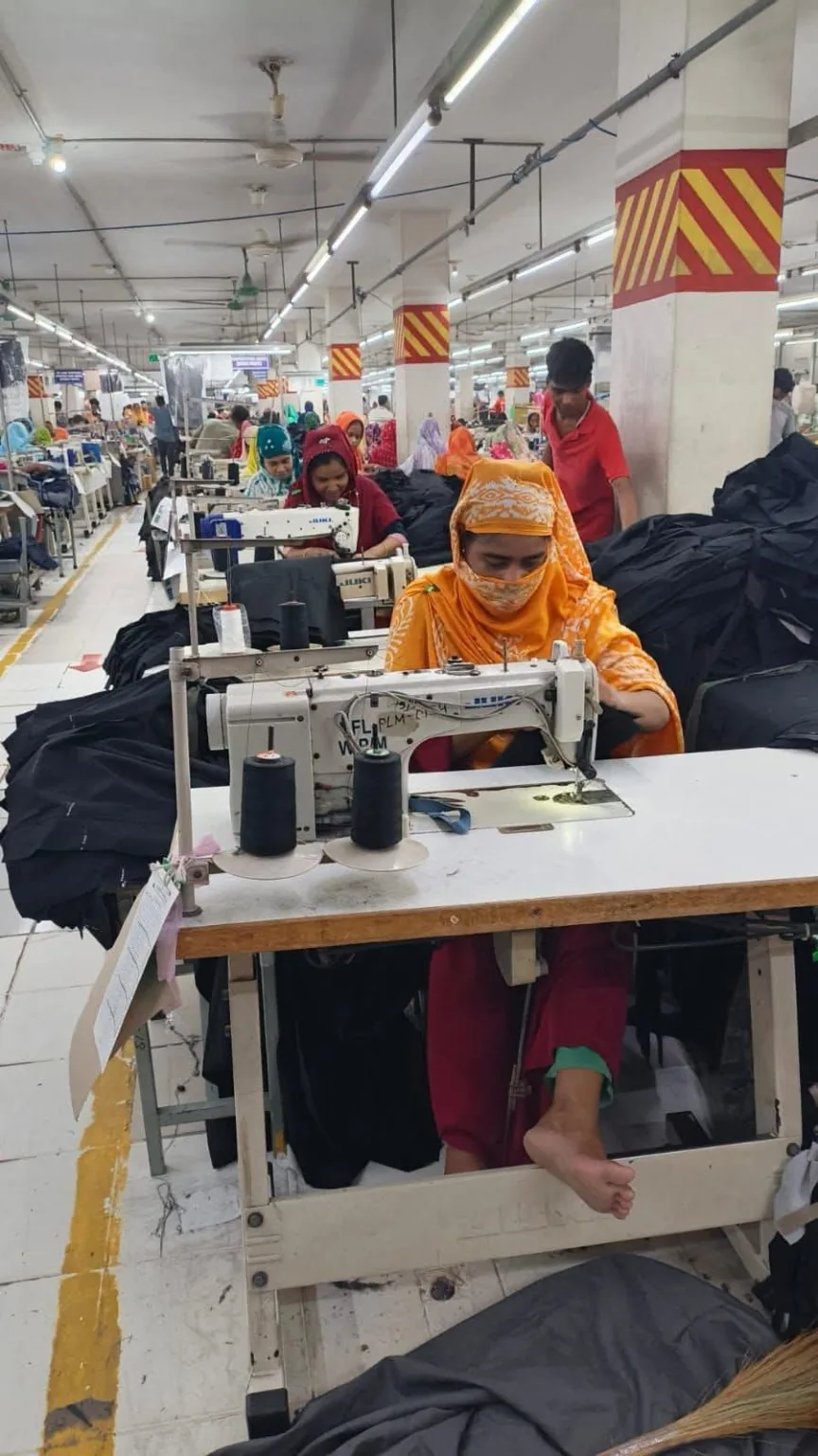 Industrial Sewing of Dark Garment Panels An operator sewing dark garment panels at an industrial sewing machine.